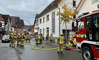 Feuerwehrleute aus vier Einheiten sind mit den Löscharbeiten in der Delbrücker Innenstadt beschäftigt. - Ralph Meyer