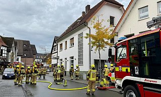 Feuerwehrleute aus vier Einheiten sind mit den Löscharbeiten in der Delbrücker Innenstadt beschäftigt. - Ralph Meyer