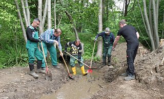 Vorarbeiter Juri Kremser, Vasin Nikolaj, Sleman Ali Kassem, Yakub Jan und Alexander Anrdt leiteen den Volmerdingsener Bach an der Ecke Weinstraße/Röhn in sein neues Bett. - Nicole Bliesener