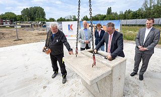 Eine Zeitkapsel hat Paderborns Bürgermeister Michael Dreier (4.v.l.) in Anwesenheit von Peter Günter (v.l., Baufirma Kögel), Steb-Leiter Markus Beine, Brunhilde Konersmann (Betriebsausschuss) und Sascha Pöppe (Betriebsausschuss) in den Grundstein eingelassen. - Niklas Tüns