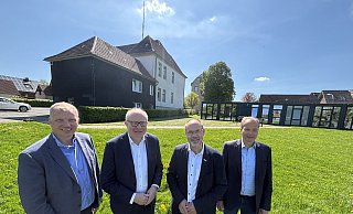 Der Altbau (l.) und die Containeranlage sollen dem Neubau weichen. An den Planungen beteiligt sind (v. l.) Hauptamtsleiter Christoph Wittler, der Landtagsabgeordnete Bernhard Hoppe-Biermeyer, Bürgermeister Christian Carl und Wirtschaftsförderer Martin Finger. - Jens Reddeker