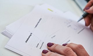 Eine Frau unterschreibt einen Arbeitsvertrag. - Annette Riedl/dpa
