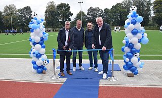 Der Kunstrasenplatz in Albaxen ist eröffnet; mit dem Bundestagsabgeordneten Christian Haase (v. l.), Gerhard Fickert (Firma Rathert), Vereinsvorsitzenden Michael Heine und Bürgermeister Daniel Hartmann beim Durchtrennen des Bandes. - Stadt