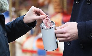 Eine Spenderin steckt auf dem Neuen Markt zehn Euro in eine Spendendose. - Frank-Michael Kiel-Steinkamp
