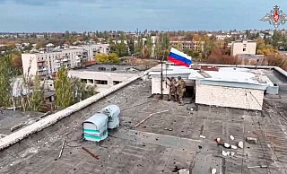 Russische Soldaten hissen in einer Ortschaft auf einem Gebäude eine Fahne nach dessen Einnahme. (Archivbild/Handout) - Uncredited/Russian Defense Ministry Press Service/AP/dpa