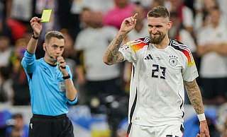 Schiedsrichter Clement Turpin zeigt Robert Andrich die gelbe Karte. - Christian Charisius/dpa