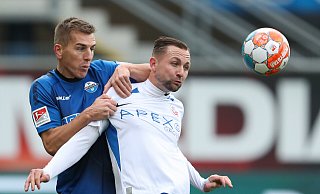 Paderborns Uwe Hünemeier (l.) im Kampf um den Ball mit Rostocks John Verhoek. - picture alliance/dpa