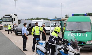 Beamte in Streifenwagen oder auf dem Motorrad ziehen Urlauber von der Autobahn. - Charlotte Mahncke
