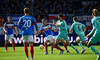 Kiels Lewis Holtby (m.) setzt sich gegen die Paderborner Maximilian Rohr (l.) und Marco Schuster durch. Rohr trifft später per Kopf zum 1:0. - dpa