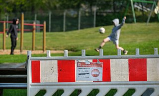 Es mutet kurios an: Auf dem Spielplatz Leharstraße kicken zwei Jungs in der verbotenen Zone, immer wieder sind auch Kinder zu sehen, die knapp neben dem Spielplatz kicken oder spielen. - Foto: Andreas Zobe/NW