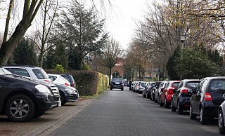 Der Friedhofsweg müsste als Zufahrt zum Parkhaus wieder in beide Richtungen geöffnet werden; heute ist er zum Großteil eine Einbahnstraße. Das seitliche Parken wie auf dem Foto rechts wäre dann nicht mehr möglich. - Copyright: Thoering / D-33161 Hoevelhof
