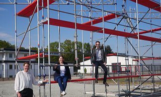 Iris Brockmeier (v. l.), Svea Ruhe und Max Weeke freuen sich auf die erste Vorstellung im Autokino Die 40 Quadratmeter große Leinwand soll an dem Stahlgerüst befestigt werden. - Klaus Karenfeld