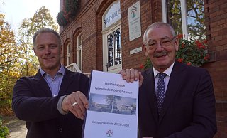 Haben damals gut lachen: Kämmerer Björn Vogt (l.) und der ehemalige Bürgermeister Ernst-Wilhelm Vortmeyer präsentieren den Doppel-Haushaltsplan der Gemeinde Rödinghausen für die Jahre 2019 und 2020. - Niklas Krämer
