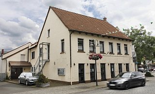 Gastwirtschaft, Kolonialwarenladen, Kino, Kindergarten, Supermarkt und Diskothek - das Haus an der Hauptstraße 4 hat eine lange und wechselvolle Geschichte. Der Versatz im Dach des Saals (hinten links) zeugt noch heute von einer Änderung der Planung während des Umbaus zum Kino 1953 - ein Nachbar hatte sich aus Furcht vor der Verschattung seines Grundstücks dagegen gewehrt. - Roland Thöring