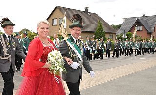 Festlicher Durchzug: Das Regentenpaar des Schützenvereins Lenzinghausen Dirk und Silke Kniepkamp marschiert zur Feierstunde an der Grundschule. Foto: Stefanie Boss - Stefanie Boss