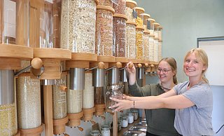 Im neuen Unverpacktladen an der Engeraner Steinstraße können sich die Kunden lose Ware aus sogenannten Bulk Bins aus Glas abzapfen. Marie Herfort und Luca Christin Melchert zeigen hier, wie es geht. - Ekkehard Wind