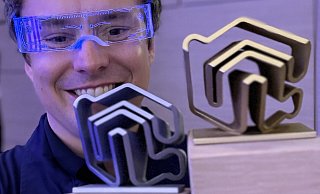 Lichtwart-Gründer Johannes Mailänder präsentiert stolz seine zwei Pokale – einmal den Gesamtsieg der PropTech Germany Awards und den Sieg in der Kategorie Smarte Gebäudeeffizienz. - Lichtwart GmbH