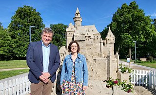 Sponsor Jan Lackmann vom Redingerhof und Gartenschau-Geschäftsführerin Rehana Rühmann sind vom imposanten Dornröschen-Schloss aus Spezialsand begeistert. - Stadt Bad Lippspringe