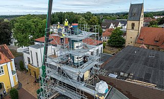 Über den Dächern von Steinhagen haben in dieser Woche die Abrissarbeiten der markanten Steinhäger-Flasche begonnen. - Ulrich Fälker
