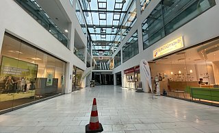 Eine Pylone steht mitten in der Halle des Lenné Karrees - sie soll die Besucher vor den Wasserpfützen aufgrund des undichten Daches warnen. - Nicole Sielermann
