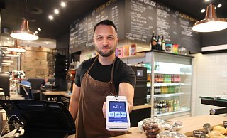 Jewin Derbas, der seit rund sechs Jahren im Kontor Kaffee in Herford arbeitet, zeigt das bargeldlose Trinkgeld-System. - Susanne Blersch