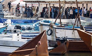 Migranten stehen an einem Hafen auf Lampedusa. - Cecilia Fabiano/LaPresse via ZUMA Press/dpa