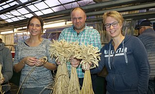 Gemeinschaftsaktion: Lena Horstkötter, Andreas Rohe und Maria Tegelkamp (v.l.) binden aus Weizen-Ähren Bunde, die dann die Laternen in Clarholz schmücken sollen. - Anja Hustert