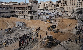 Palästinenser beobachten Mitglieder der militanten Hamas-Gruppe bei der Suche nach den Leichen der Geiseln in einem Gebiet in Hamad City, Chan Junis, im südlichen Gazastreifen. - Jehad Alshrafi/AP/dpa