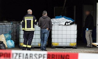 Feuerwehr und Ermittler untersuchen im April 2019 die Lagerhalle in Preußisch Oldendorf. - Foto: Oliver Krato/dpa
