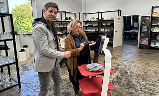 Steven Murphy vom Bielefelder Gastronomie-Ausstatter Schulze und Hase erklärt der ostwestfälischen Dehoga-Geschäftsführerin Regine Tönsing, wie ein Service-Roboter programmiert und eingesetzt wird. - mika