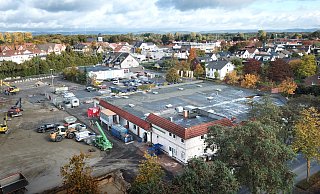 Der Edeka-Markt Niederschulte in Verl (r.) wird komplett entkernt und modernisiert. Das gilt auch für Fassade und Dach. Dort, wo der alte Aldi-Markt stand, haben derzeit die Baufahrzeuge das Sagen (l.). An gleicher Stelle wird ein neuer größerer Aldi entstehen. - Andreas Frücht