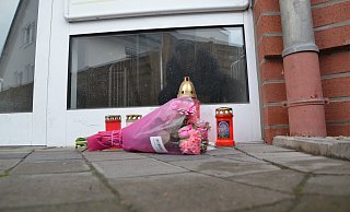 Vor dem Haus in Borgholzhausen, in dem die getötete 37-Jährige lebte, liegen Blumen und Kerzen. - Andreas Großpietsch