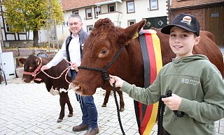 Auf dem Borgholzer Marktplatz präsentieren Jonas (r.) Mutterkuh „Edelweis“ und Vater Stephan Hoppe Kalb „Enzian“, das im Mai geboren wurde. Das einfache S am Namensende des Pinzgauer-Rindes sei einem Rechtsschreiberfehler im Herdbuch geschuldet, der sich seit dem ersten Eintrag nun durchziehe, sagt der erfolgreiche Züchter.?Fotos: Dieter Scholz - Dieter Scholz