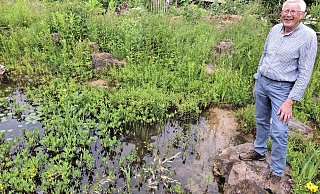 Friedhelm Diebrok an seinem Gartenteich, in dem sich zurzeit wenig Wasser befindet. Tiere können dort aber auch jetzt noch ihren Durst löschen – oder ein Bad nehmen. - Meiko Haselhorst