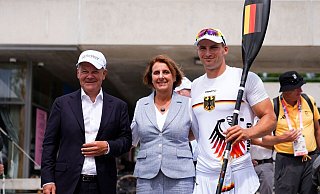 Bundeskanzler Olaf Scholz (l) und seine Frau Britta Ernst lassen sich mit Olympiasieger Tom Liebscher-Lucz fotografieren. - Lindsey Wasson/AP/dpa