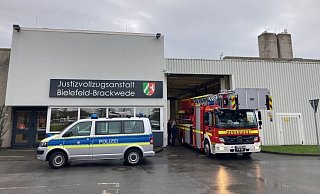 Während Rettungskräfte durch das offen stehende Gefängnistor fahren, bewachen Polizisten und Justizbeamte die sonst geschlossene Schleuse. - Jens Reichenbach
