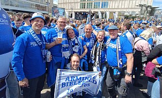 Claudius Blume (v. l.), Stefan und Jana Meyer, Ex-Schützenkönig Dirk Ciesla, Britta Ciesla, Frank Dawitz und Bastian Dawitz (knieend) beim Fanfest auf dem Alexanderplatz. - Oerlinghauser Schützengesellschaft