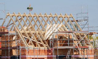 Mit einem Kranz wird beim Neubau eines Einfamilienhauses in der Region Hannover Richtfest gefeiert. - Mia Bucher/dpa