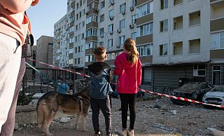 Kriegsalltag: Kinder schauen in Kiew auf ein bei russischen Raketenangriffen beschädigtes Gebäude. - Danylo Antoniuk/ZUMA Press Wire/dpa