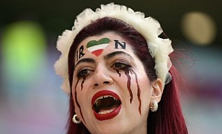Eine Frau aus dem Iran steht vor dem Spiel auf der Tribüne. - Federico Gambarini/dpa
