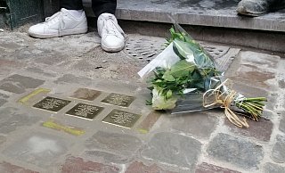 Ein Blumenstrauß liegt am internationalen Holocaust-Gedenktag neben sogenannten «Stolpersteinen», die an Opfer des Holocaust erinnern sollen. - Gabriel Mitran/BELGA/dpa/Symbolbild
