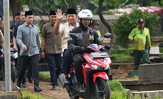 Prabowo Subianto wird von einem Polizisten zum Grab seines Vaters in Jakarta gefahren. - Tatan Syuflana/AP/dpa