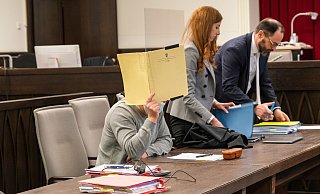 Edgar K. schützt sein Gesicht mit einer Mappe. Neben ihm legen seine Verteidiger Carina Tofall und Matthias Cramer ihre Unterlagen bereit. - Lena Henning (Archivfoto)