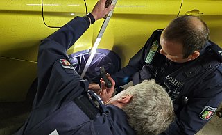 Zwei Polizeibeamte messen bei einer Großkontrolle im September 2022 nach, ob das Fahrwerk noch auf einer erlaubten Höhe eingestellt ist. - Gerald Dunkel