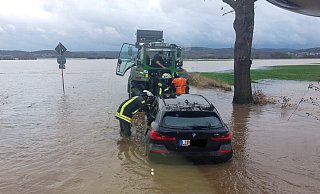 Das Wasser steht dem Feuerwehrmann bis zum Oberschenkel. Alleine hätten sich die Insassen des Autos wohl nicht befreien können. - Feuerwehr Porta/Michael Horst
