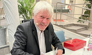 Jürgen Becker signiert in der Pause seine Bücher in der Delbrücker Stadthalle. - Carola Drabon