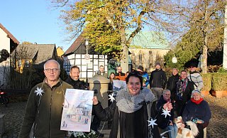 Mit viel Unterstützung bei den letzten Vorbereitungen: Nadja Rellin und Paul Schulze-Sünninghausen (vorne) vom Organisationsteam freuen sich auf den Adventszauber am Brunnen, dem Mittelpunkt von Kirchdornberg. Das Plakat hat Anne Schüler gestaltet. - Ivonne Michel
