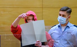 Der Angeklagte in Kapuzenjacke ist auch von den Justizbeamten kaum zu stoppen. Unentwegt stört er mit lautem Gerede in russischer Sprache die Verhandlung. Trotz gutem Zuredens lässt er sich nicht beruhigen, versucht, die Mikrophonanlage zu demolieren und droht, die Sicherheitskräfte anzugreifen. - Andreas Zobe