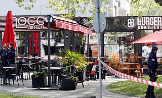 Polizisten haben einen Tatort am Marktplatz, eine Cafe-Bar, mit Flatterband abgesperrt. - Roland Weihrauch