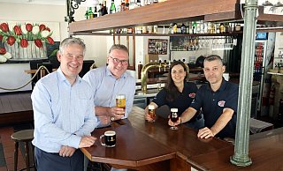 Die große Auswahl an Biersorten ist ein Alleinstellungsmerkmal der Gaststätte Einstein. Bürgermeister Michael Berens, Wirtschaftsförderer Thomas Westhof und die Inhaber des Lokals, Maria Tsamadia und Paschalis Giannikis (v.l.) präsentieren eine Auswahl der Getränkekarte. - Gemeinde Hövelhof